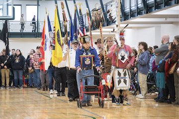 Tribe members parade with flags during the Grand Entry at the 39th Annual Powwow of Love