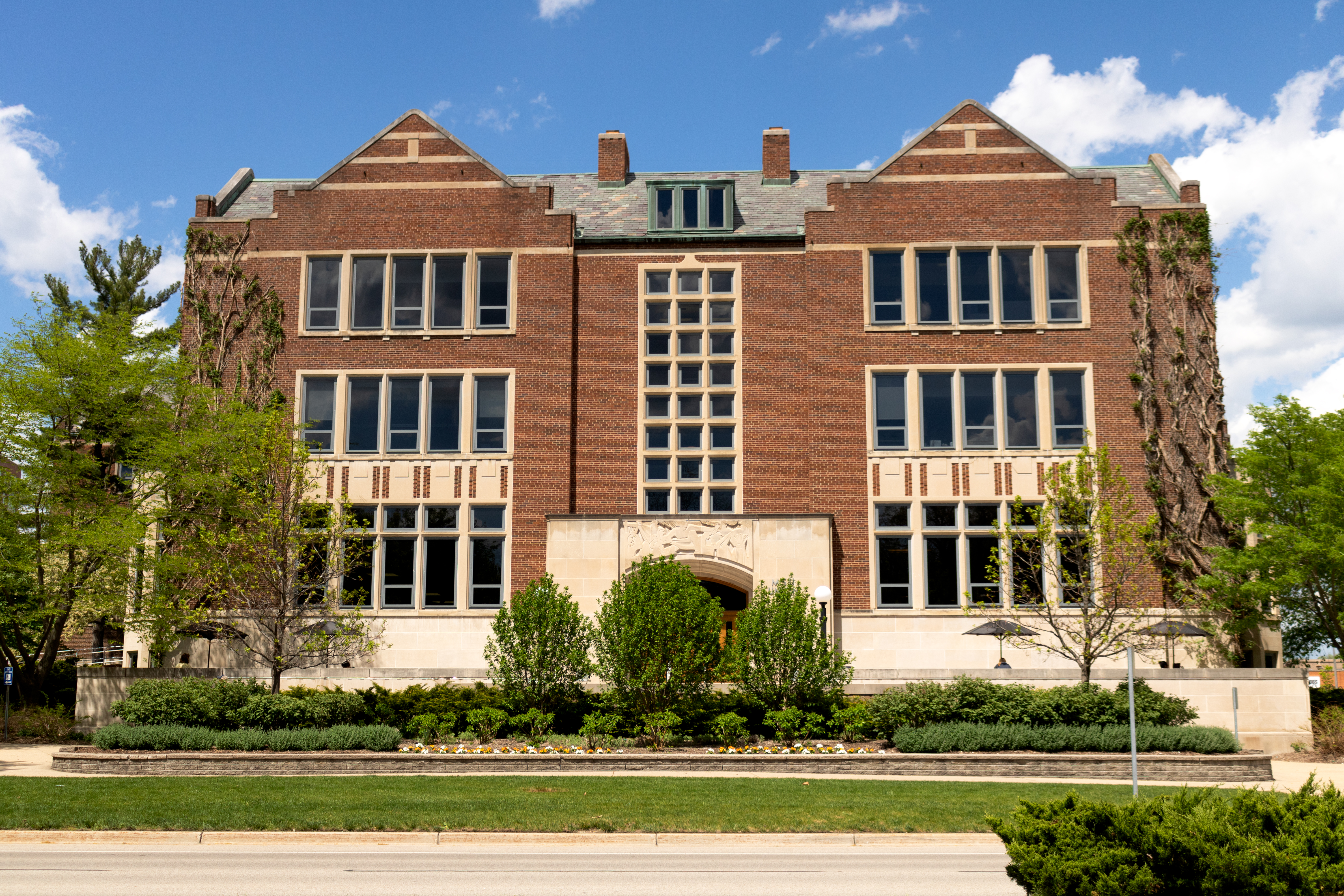 And external shot of the MSU Union building in spring surrounding by blue sky and green trees