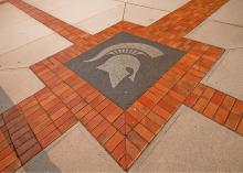 The Spartan helmet is pictured in cement on the ground on MSU's campus.