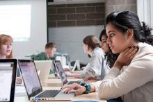 Spartans working diligently on laptops in a collaborative learning environment at Michigan State University.