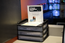 The new battery collection drawers and signage sit on a counter in an MSU residence hall.