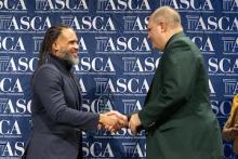 Dr. Kyle Williams shakes Rick Shafer's hand as Rick accepts his award.