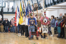 Tribe members parade with flags during the Grand Entry at the 39th Annual Powwow of Love